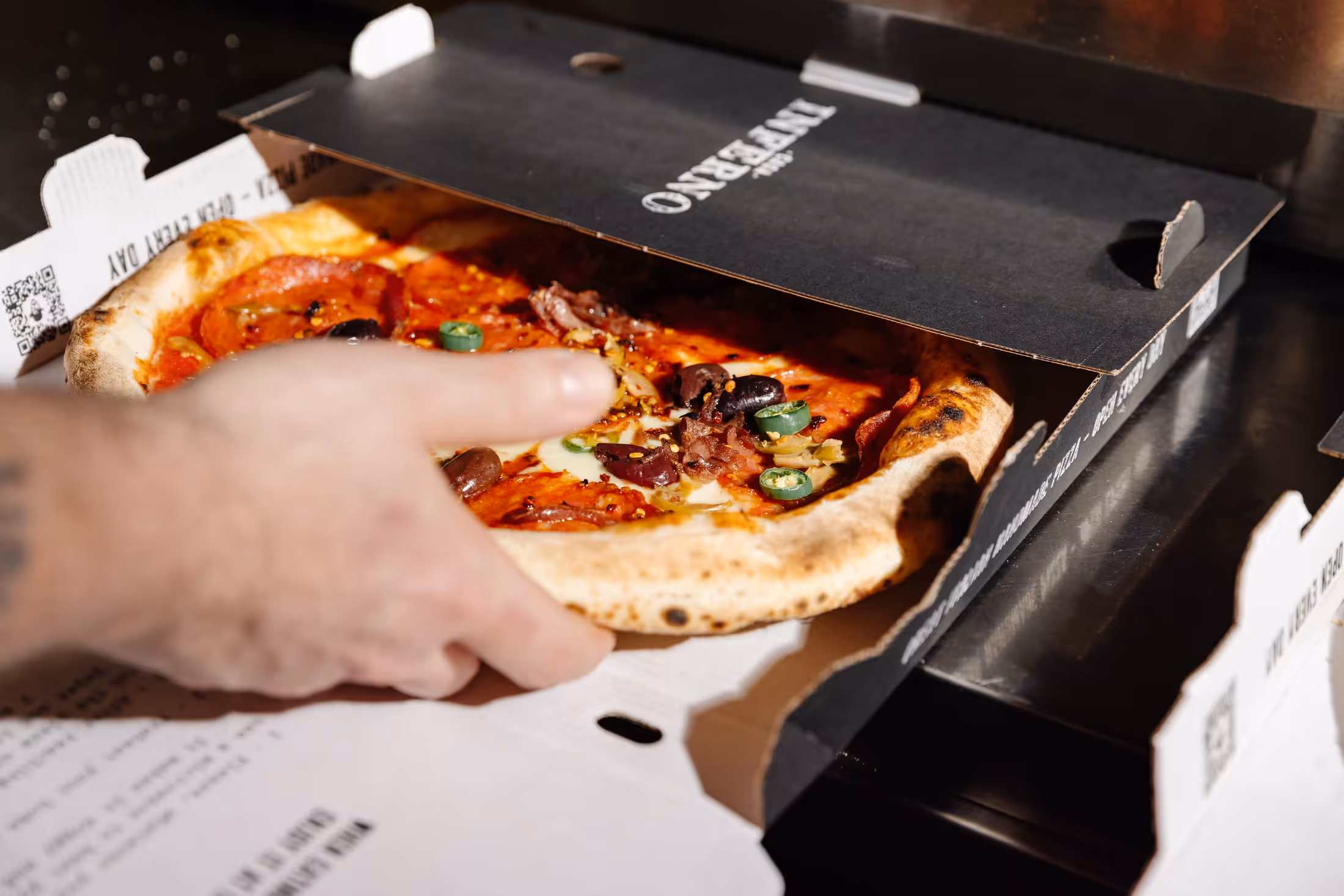 Pizza being boxed for takeaway